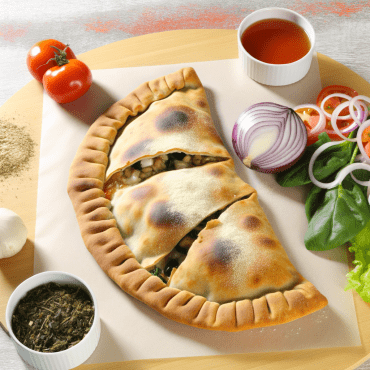 El Calzone Pugliese tradicional es una sabrosa pizza doblada rellena de cebolla, anchoas, alcaparras y aceitunas negras, cocida hasta que esté dorada. Enriquece el sabor con tomates cherry para un toque fresco y ligeramente ácido. ¡Perfecto para una comida rápida y llena de sabor!